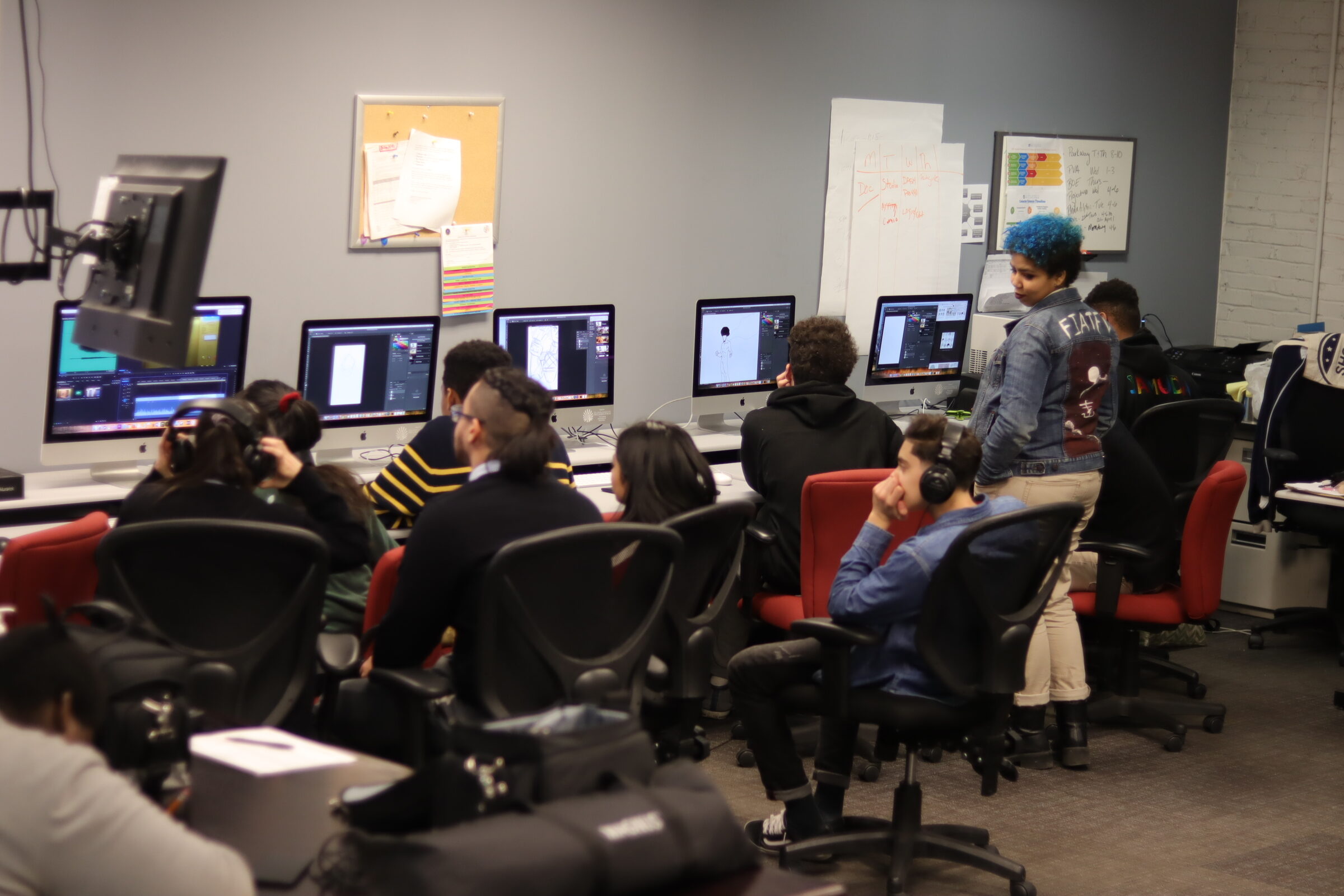 A group of people sitting in front of computers.